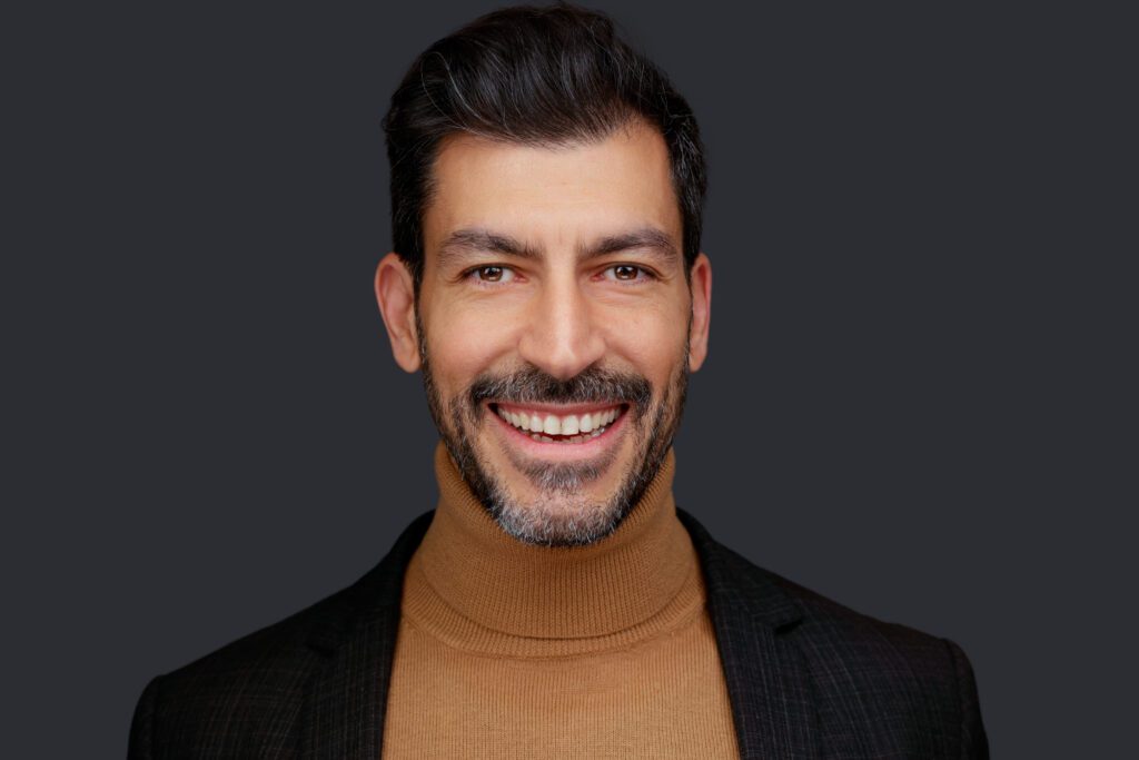 Volume headshot from TREF Conference- Smiling man in turtleneck